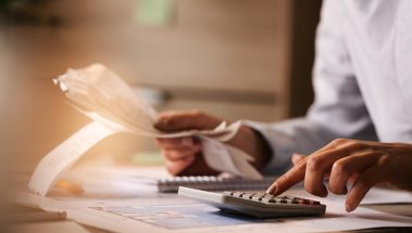 closeup-economist-using-calculator-while-going-through-bills-taxes-office closeup-economist-using-calculator-while-going-through-bills-taxes-office